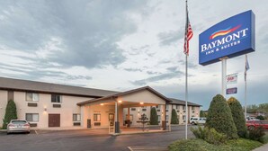 A Baymont Inn & Suites with a guest registration area, parking lot, and a sign indicating AAA and HBO affiliations. - Baymont by Wyndham Hot Springs (Hot Springs)