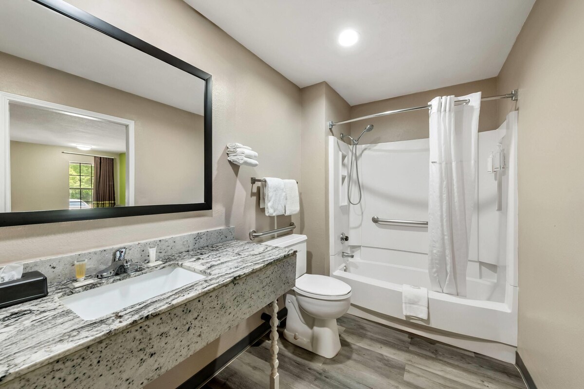 Un bagno con lavabo in marmo, un water, una vasca da bagno e una doccia.
