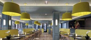 A restaurant with high ceilings, yellow pendant lights, and a central aisle. - Westminster Hotel (Livingston)