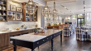 A spacious kitchen with a large island, wooden cabinets, and pendant lighting. - Omni Charlottesville Hotel (Charlottesville)