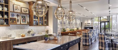 A spacious kitchen with a large island, wooden cabinets, and pendant lighting.
