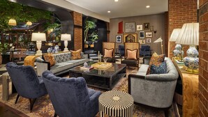 A modern lounge area with comfortable seating, a coffee table, and a brick accent wall. - Omni Charlottesville Hotel (Charlottesville)