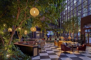A spacious indoor area with a checkered floor, seating arrangements, and hanging lights.