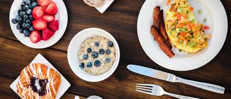 Un desayuno con diversas opciones de comida, como tostadas, huevos, tocino y fruta.