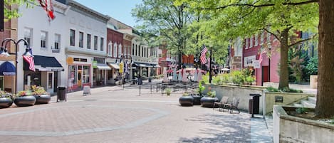 A pedestrian street lined with shops and outdoor seating areas.
