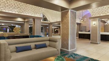 A lobby with a sofa, a reception desk, and a patterned wall.