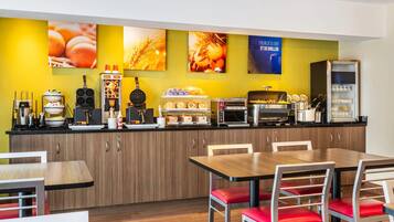 A modern breakfast bar with a variety of food and drink options, wooden cabinets, and red cushioned chairs.