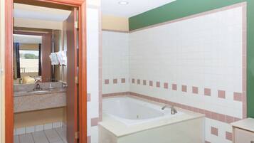 Un baño con una bañera, un lavamanos y un espejo.
