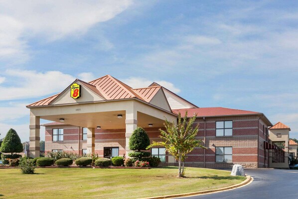 A hotel with a covered outdoor area, brick facade, and a clear sky. - Super 8 by Wyndham Jacksonville AR (Jacksonville)
