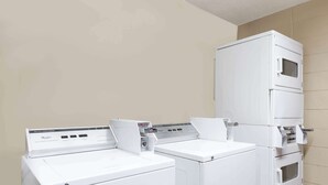 A laundry room with three stacked washers and dryers. - Super 8 by Wyndham Jacksonville AR (Jacksonville)