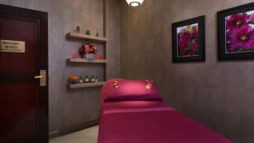 Relax in a serene space with a comfortable bed, seating area, and decorative shelf.