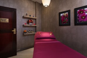 Relax in a serene space with a comfortable bed, seating area, and decorative shelf.