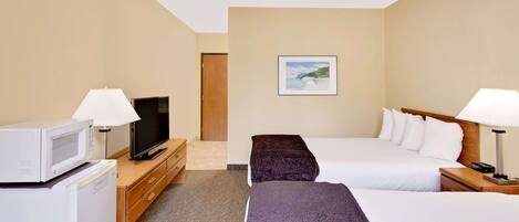 Une chambre d’hôtel avec deux lits, une télévision, un four à micro-ondes et un tableau au mur.