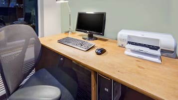 Un espace de travail comprenant un bureau, un ordinateur, un clavier, une souris et une imprimante.