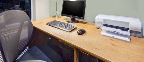 A workspace with a desk, computer, keyboard, mouse, and printer.