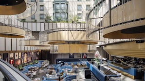 A spacious atrium with a central seating area, multiple levels of balconies, and a high ceiling with natural light. - Radisson Collection Grand Place Brussels (Brussels)
