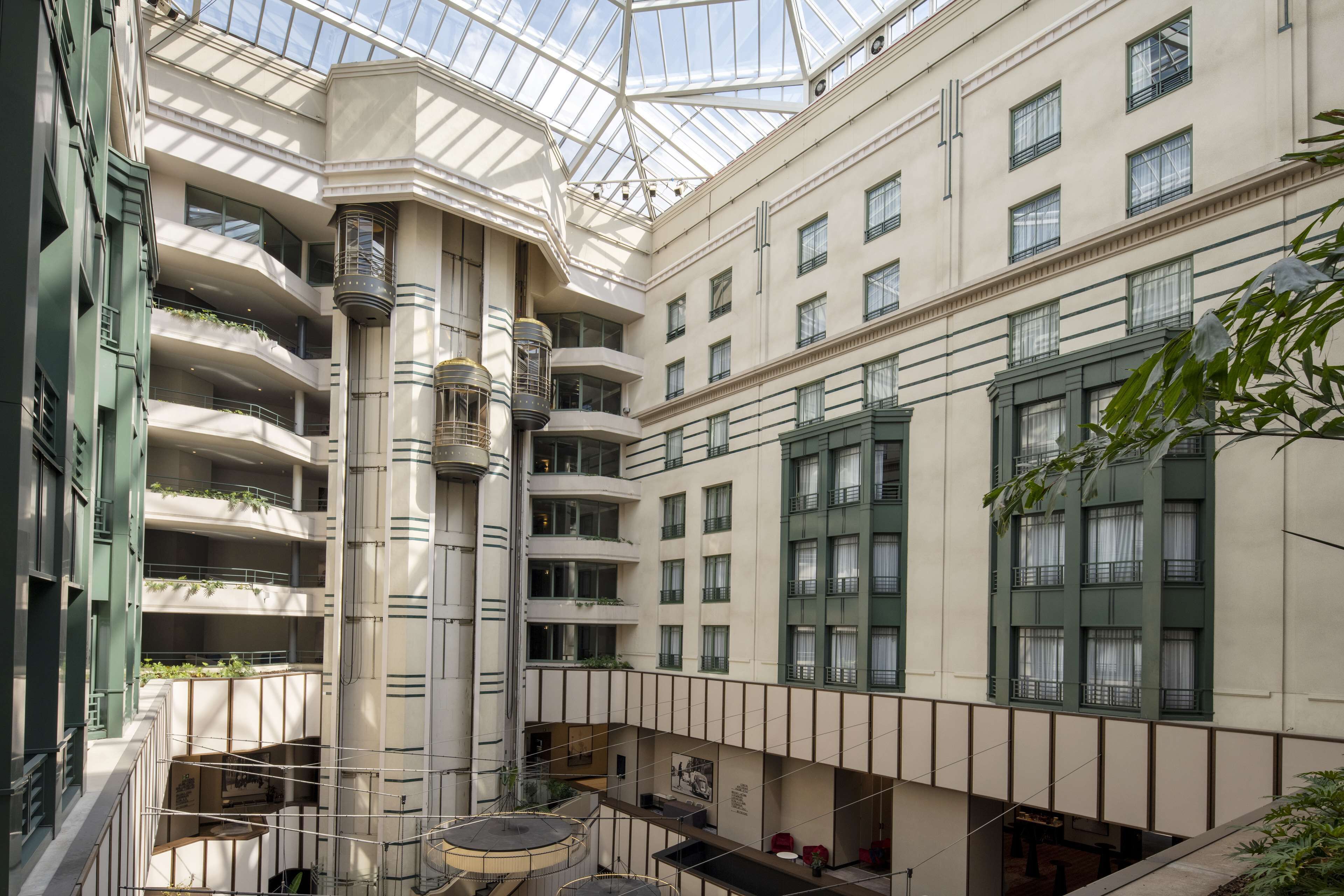 A multi-level atrium with a glass ceiling, balconies, and a central column.