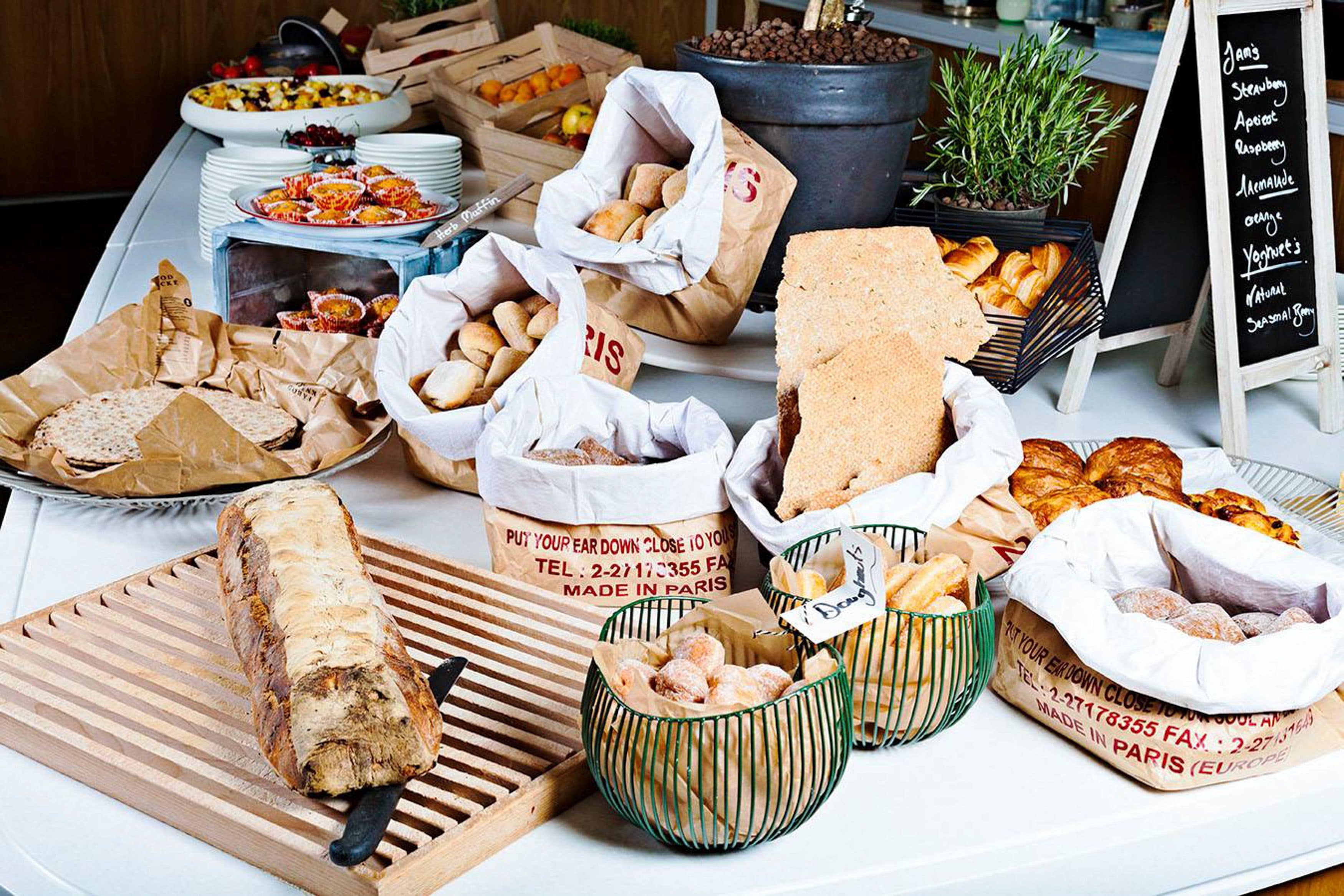 Diverse gebakken producten en patisserie, waaronder brood, croissants en ander vers gebak, gepresenteerd op een tafel.
