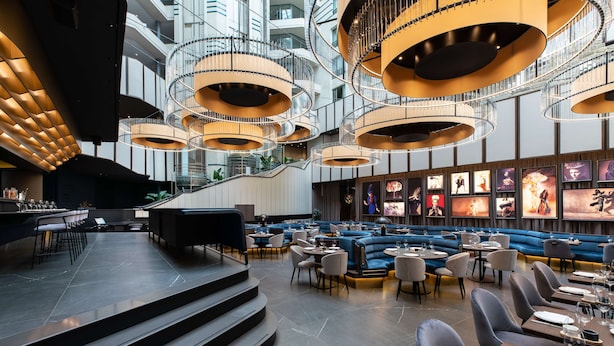 A modern interior with a central staircase, seating areas, and a bar. - Radisson Collection Grand Place Brussels (Brussels)