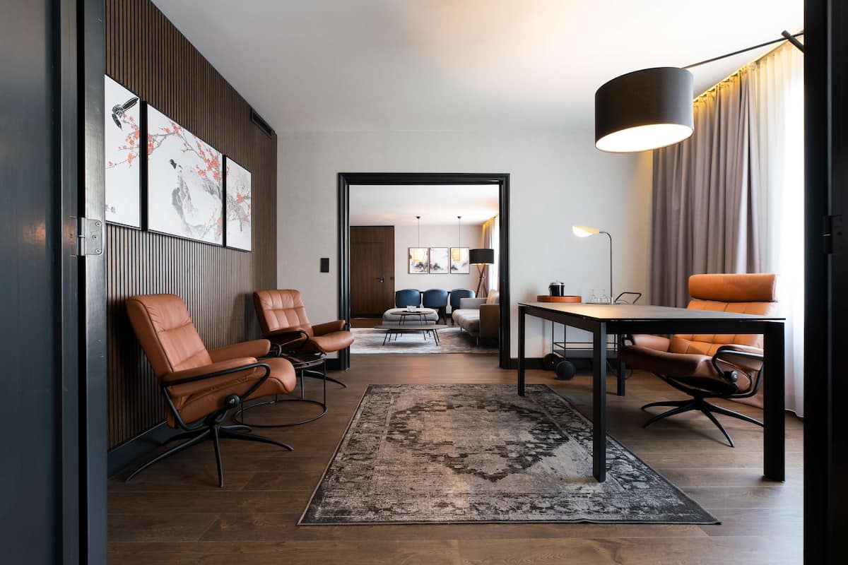 Un salon moderne avec des fauteuils en cuir, une table basse et un tapis.