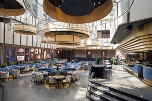 A modern interior with a central spiral staircase, multiple seating areas, and a bar counter.