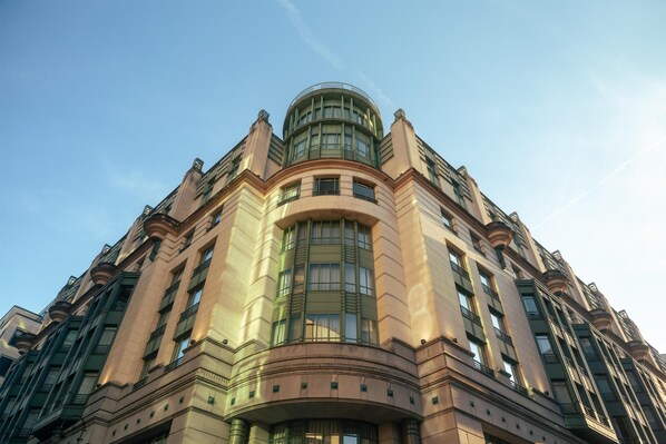 A multi-story building with a curved facade, large windows, and a central dome.