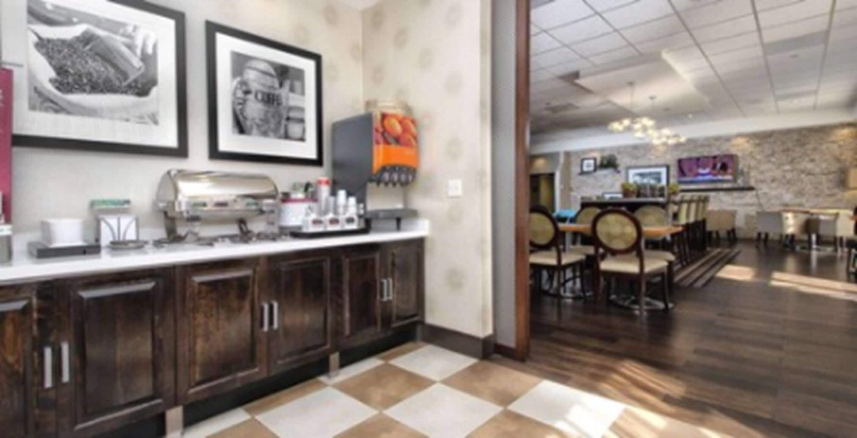 A modern kitchen with dark wooden cabinets, a white countertop, and a checkered floor.