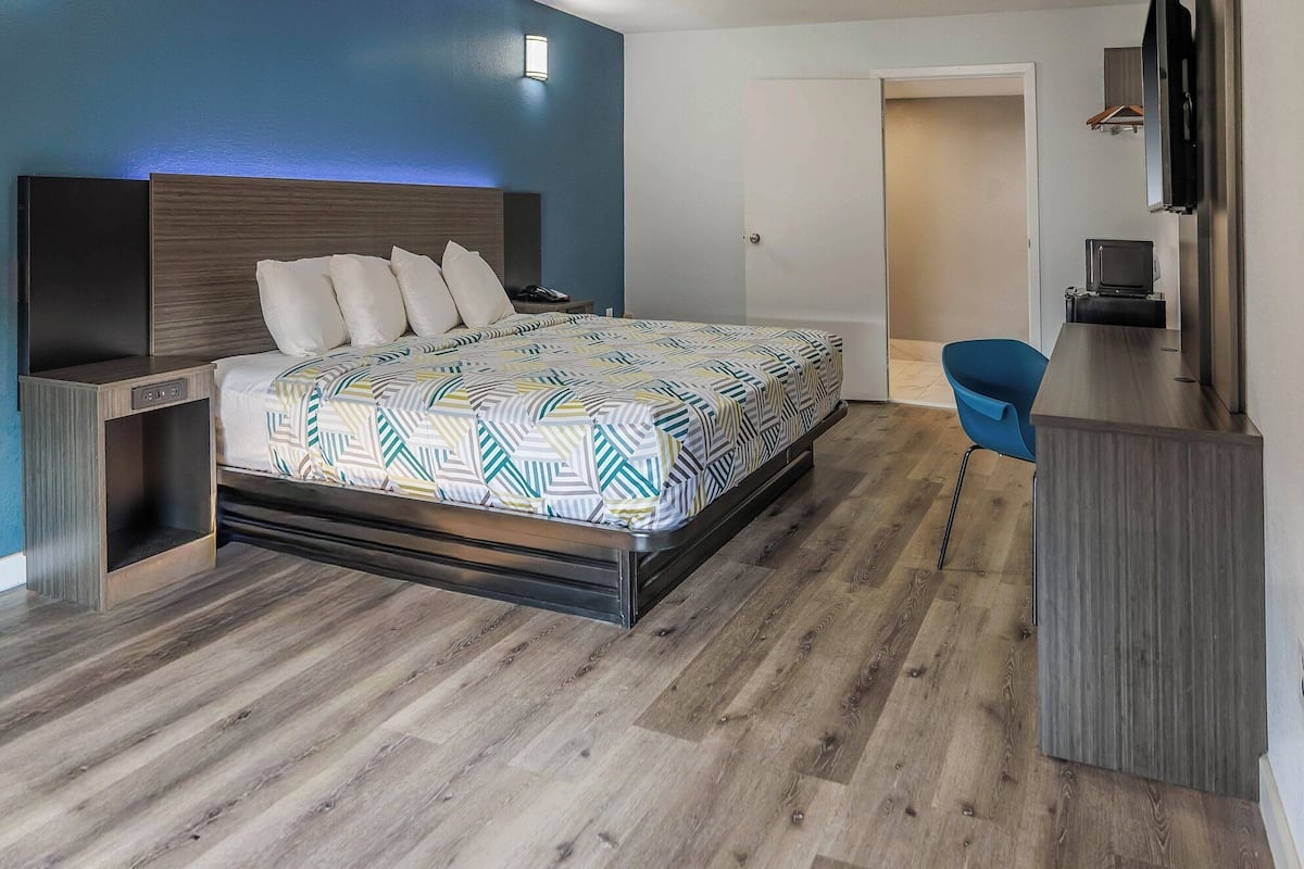 Un dormitorio moderno con cama, escritorio y silla.