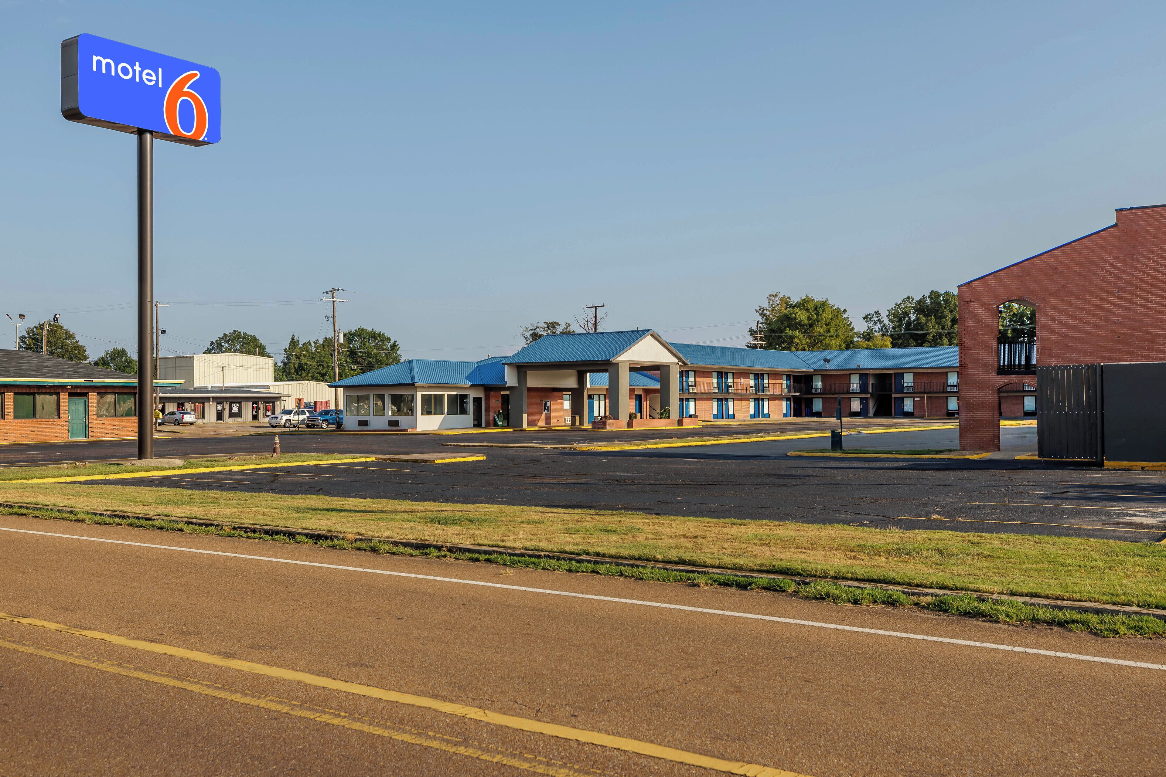 A motel with a blue sign reading "motel 6" and a parking lot in front.