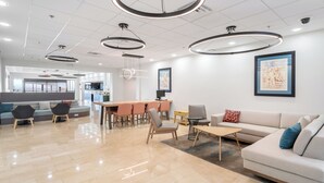 Un intérieur moderne avec un coin repas, des canapés et une cuisine en arrière-plan.