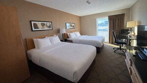 A hotel room with two beds, a desk with a TV, and a view of the beach. - Comfort Inn Baie-Comeau (Baie Comeau)