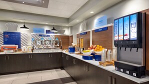 A modern kitchen area with a breakfast bar, a fruit display, and a beverage dispenser. - Holiday Inn Express Vancouver-Metrotown (Burnaby) by IHG (Burnaby)