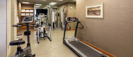 A gym with treadmills, an elliptical, and a stationary bike.