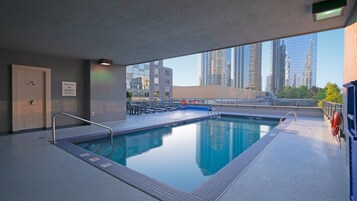 Una piscina al aire libre, sillones reclinables de piscina