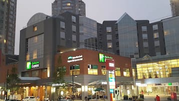 A multi-story hotel with a Holiday Inn Express sign, a Starbucks, and a Best Buy store.