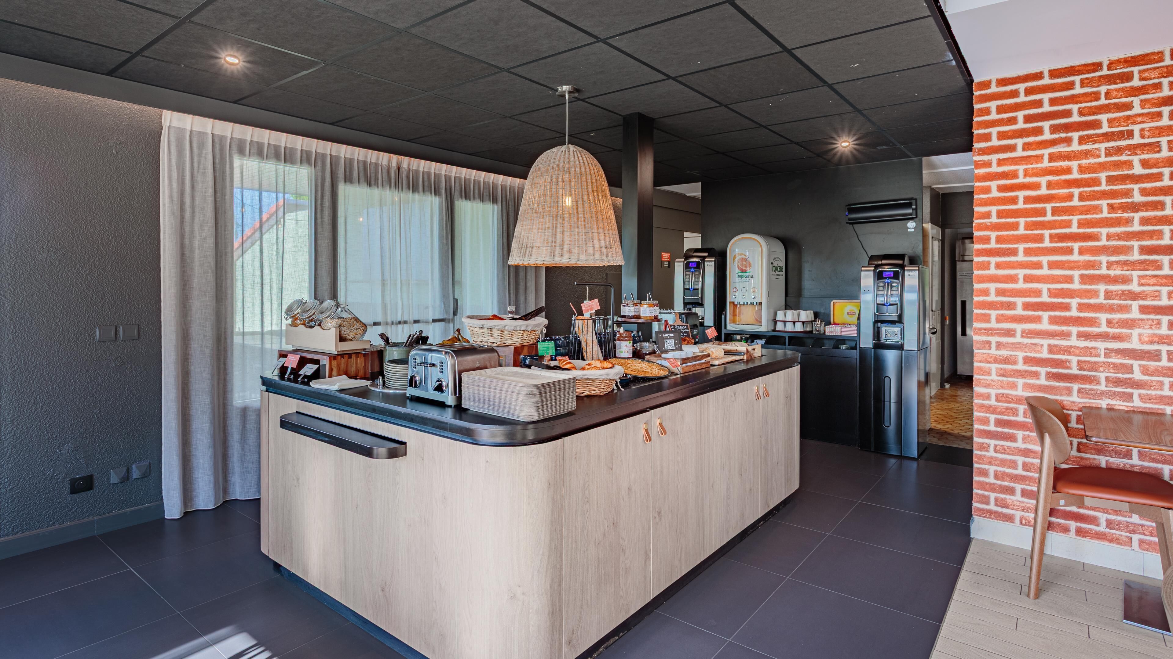 Een moderne keuken met een centraal eiland, een koffieapparaat en een broodvitrine.