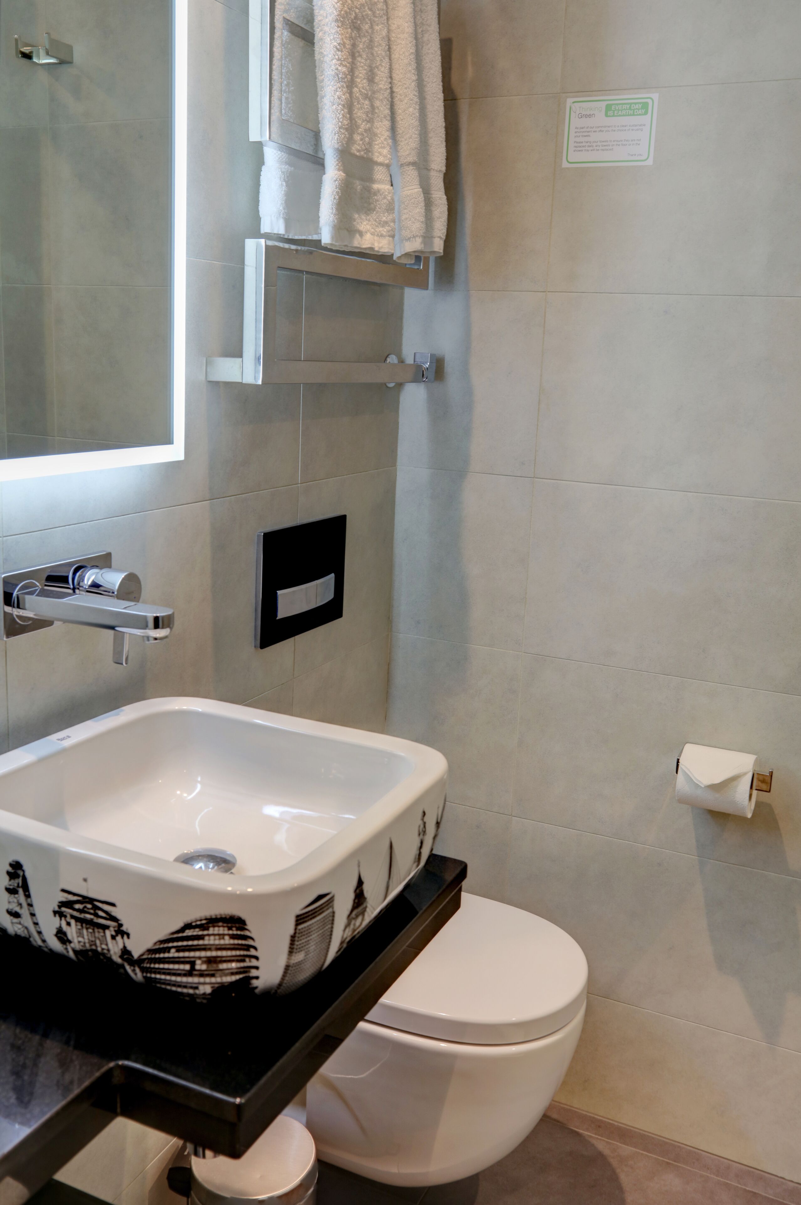 Een badkamer met een wit wastafel, toilet en handdoekhouder.