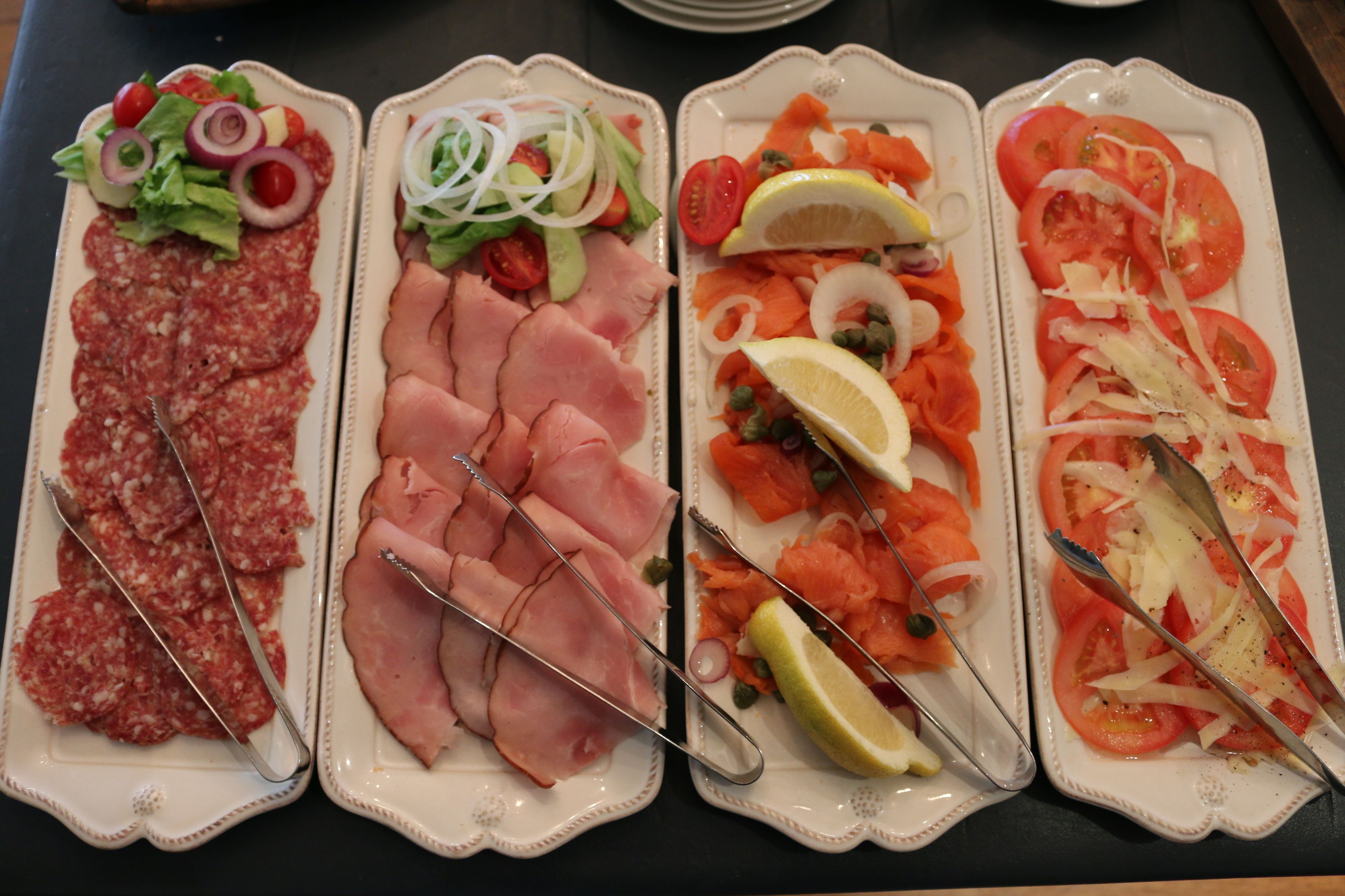 Cuatro platos de comida con diversas carnes y verduras.