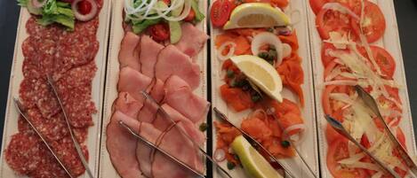 Cuatro platos de comida con diversas carnes y verduras.