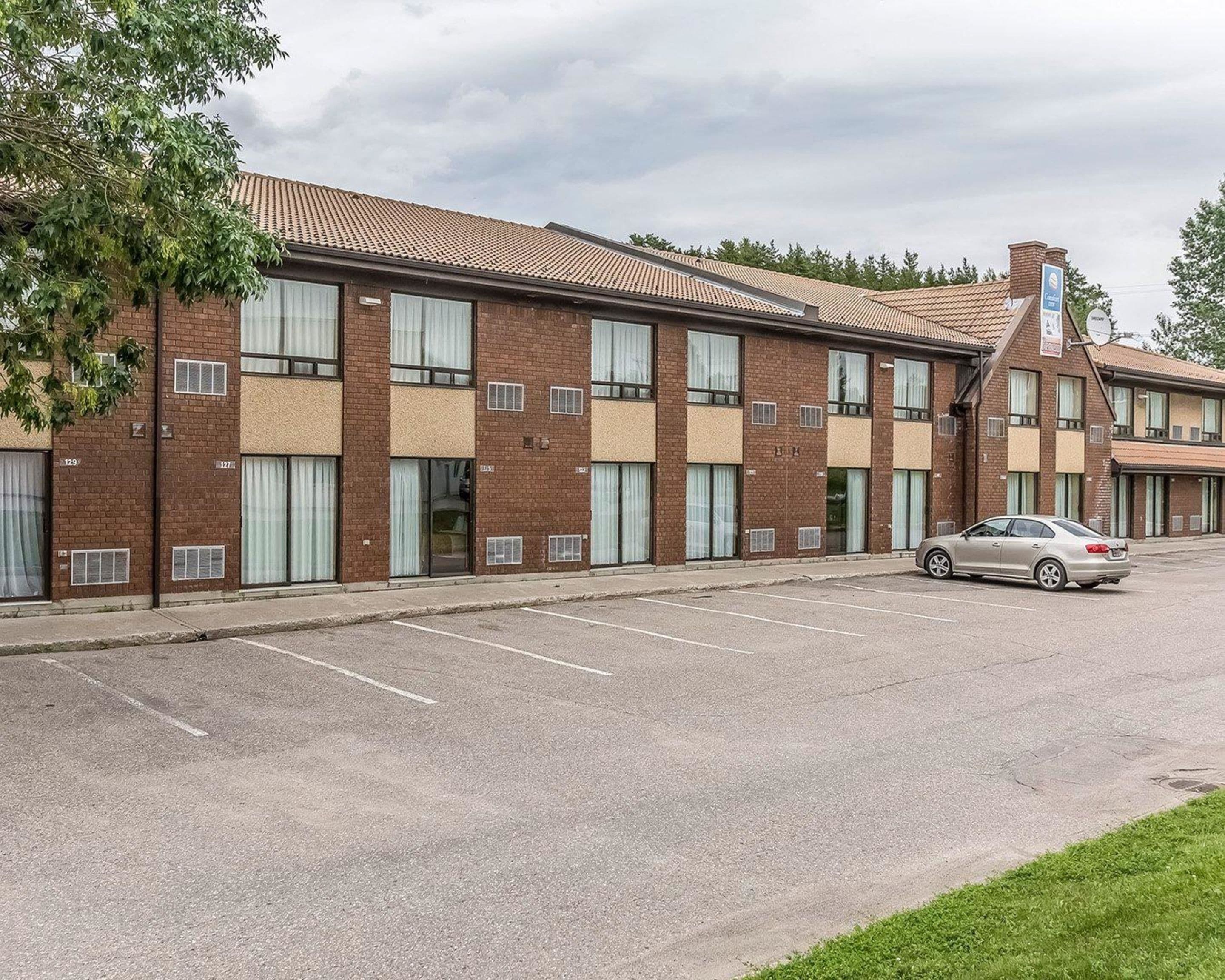 A multi-story brick building with a parking lot in front.