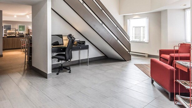 A modern interior with a staircase, office area, and seating.