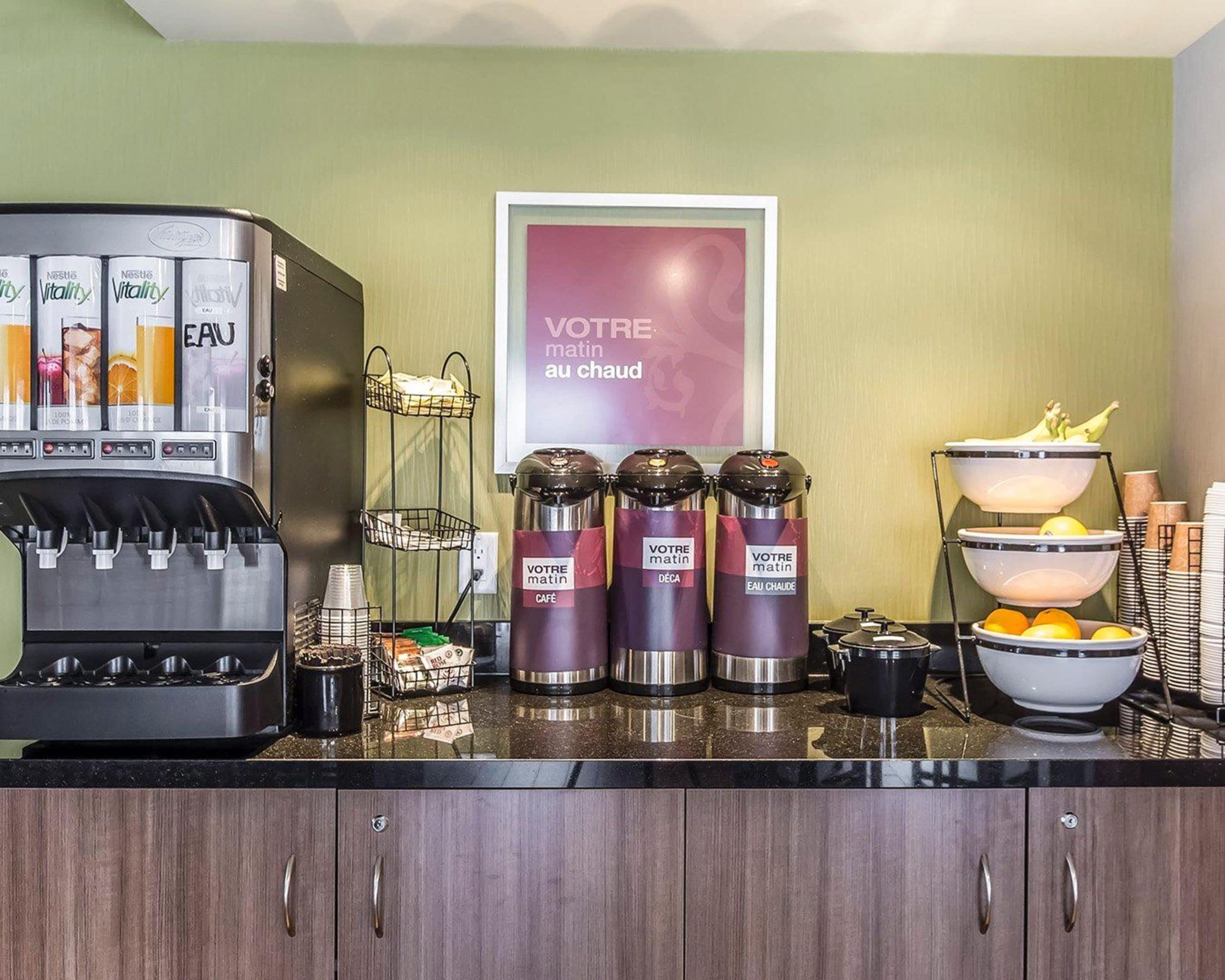 A breakfast bar with a coffee machine, condiment dispensers, and a fruit bowl.