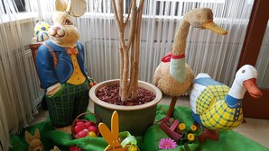 A room with a large potted plant, a wooden duck, a rabbit, and a duck figurine. - Hotel Merian Rothenburg (Rothenburg ob der Tauber)