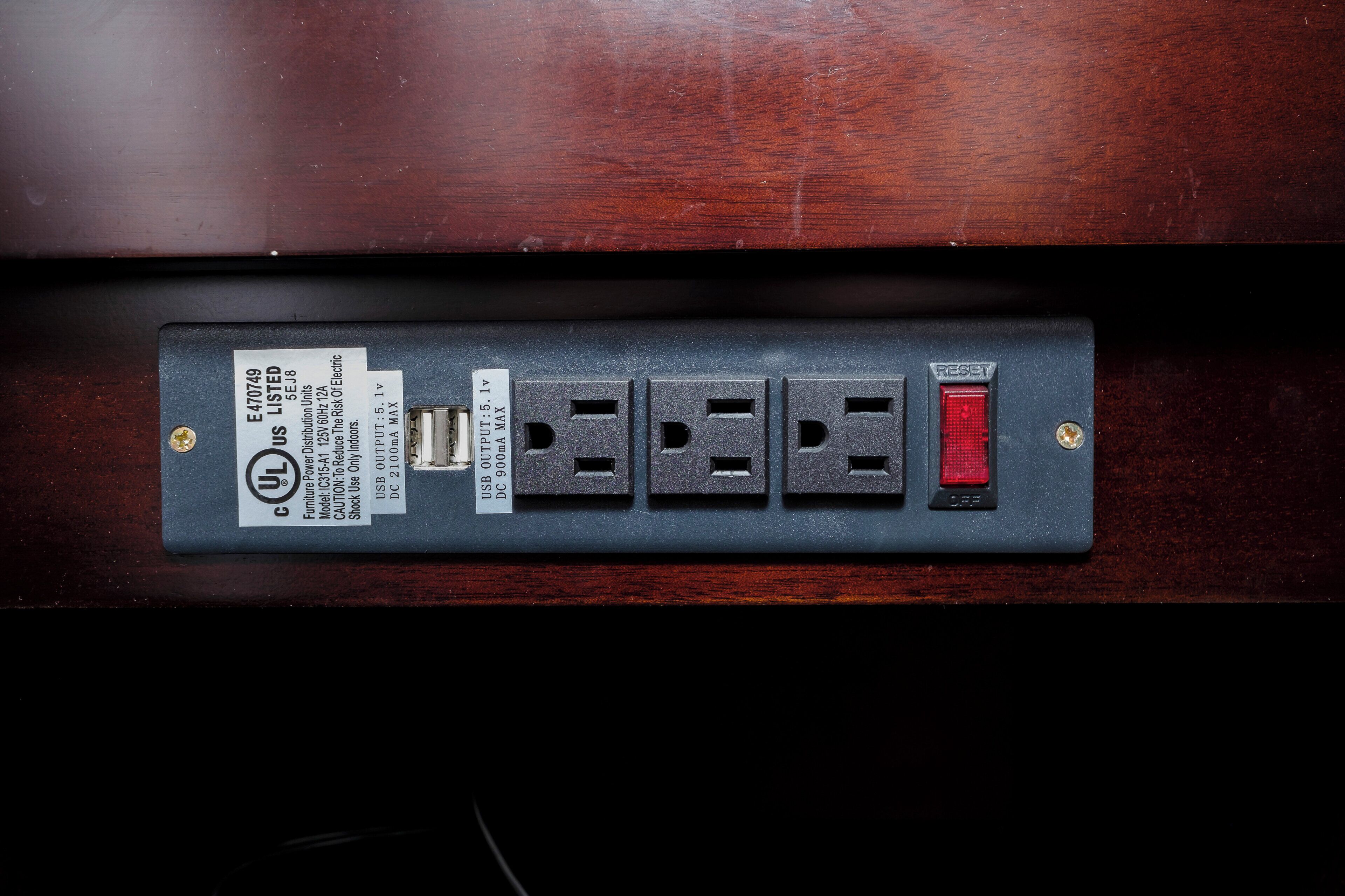 A power strip with multiple outlets and a red reset button.