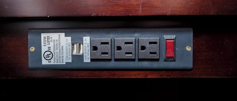 A power strip with multiple outlets and a red reset button.