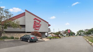 A Red Roof Inn with a modern design, a parking lot, and a clear sky. - Red Roof Inn Lansing East – MSU (Lansing)