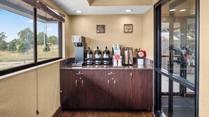 A kitchen area with a coffee station, including a coffee maker, grinders, and a coffee machine. - Red Roof Inn Lansing East – MSU (Lansing)