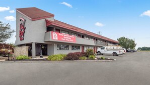 A motel with a red roof and a sign advertising low weekly rates and free pet stays. - Red Roof Inn Lansing East – MSU (Lansing)
