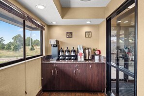 A coffee station with a coffee machine, cups, and a sign that says 'Coffee the other vitamin.' - Red Roof Inn Lansing East – MSU (Lansing)