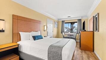 Une chambre d’hôtel avec un grand lit, un bureau, une armoire et une vue sur l’extérieur.